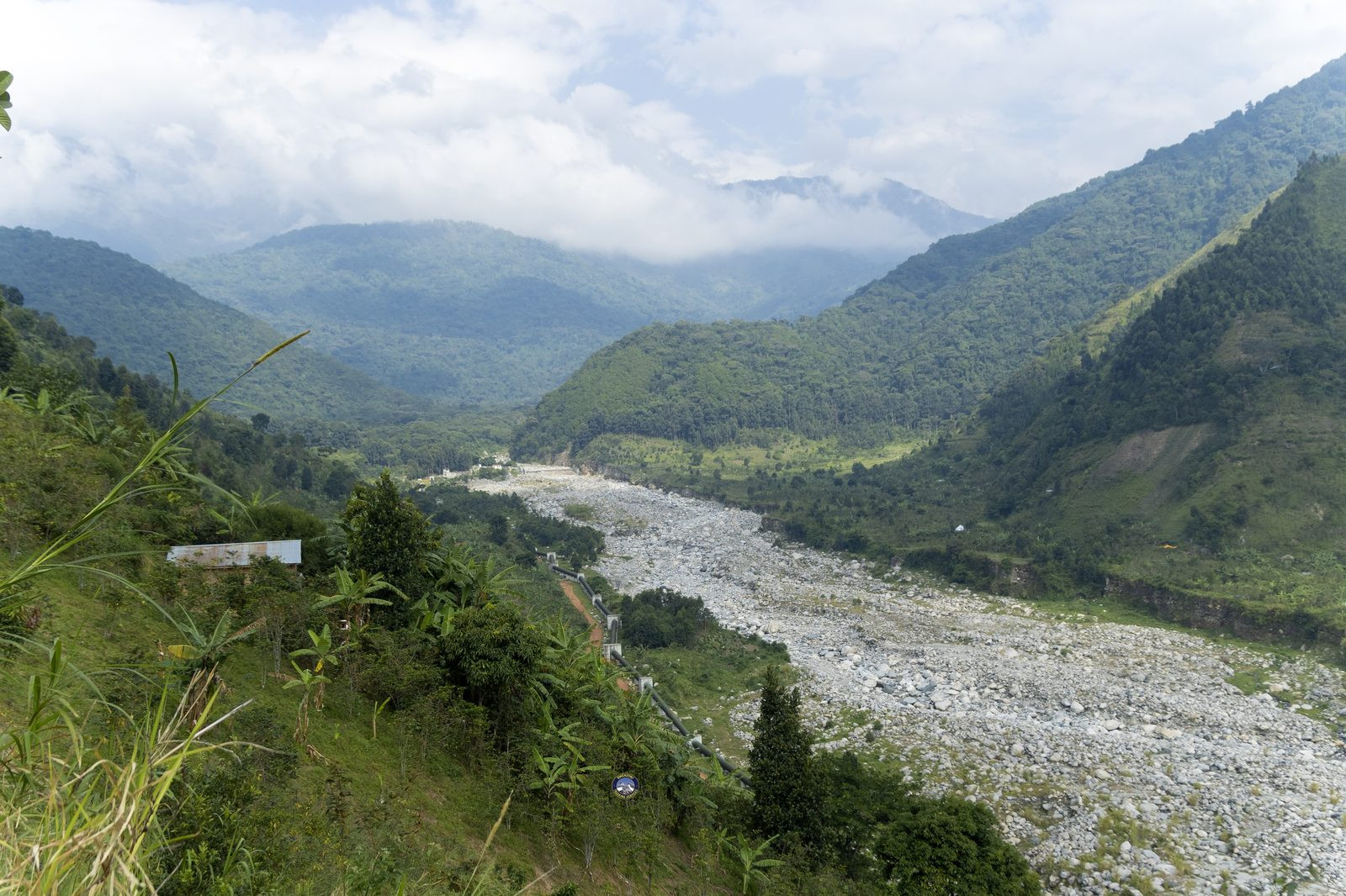 Boulder-strewn river valley leading toward the mountains