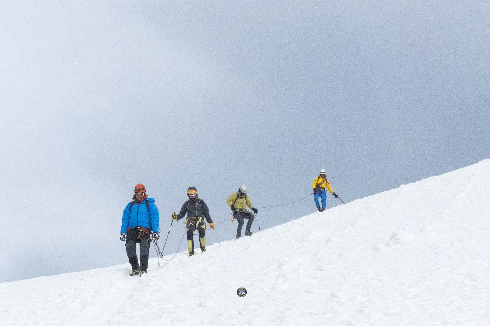 Roped climbers ascending a snow slope
