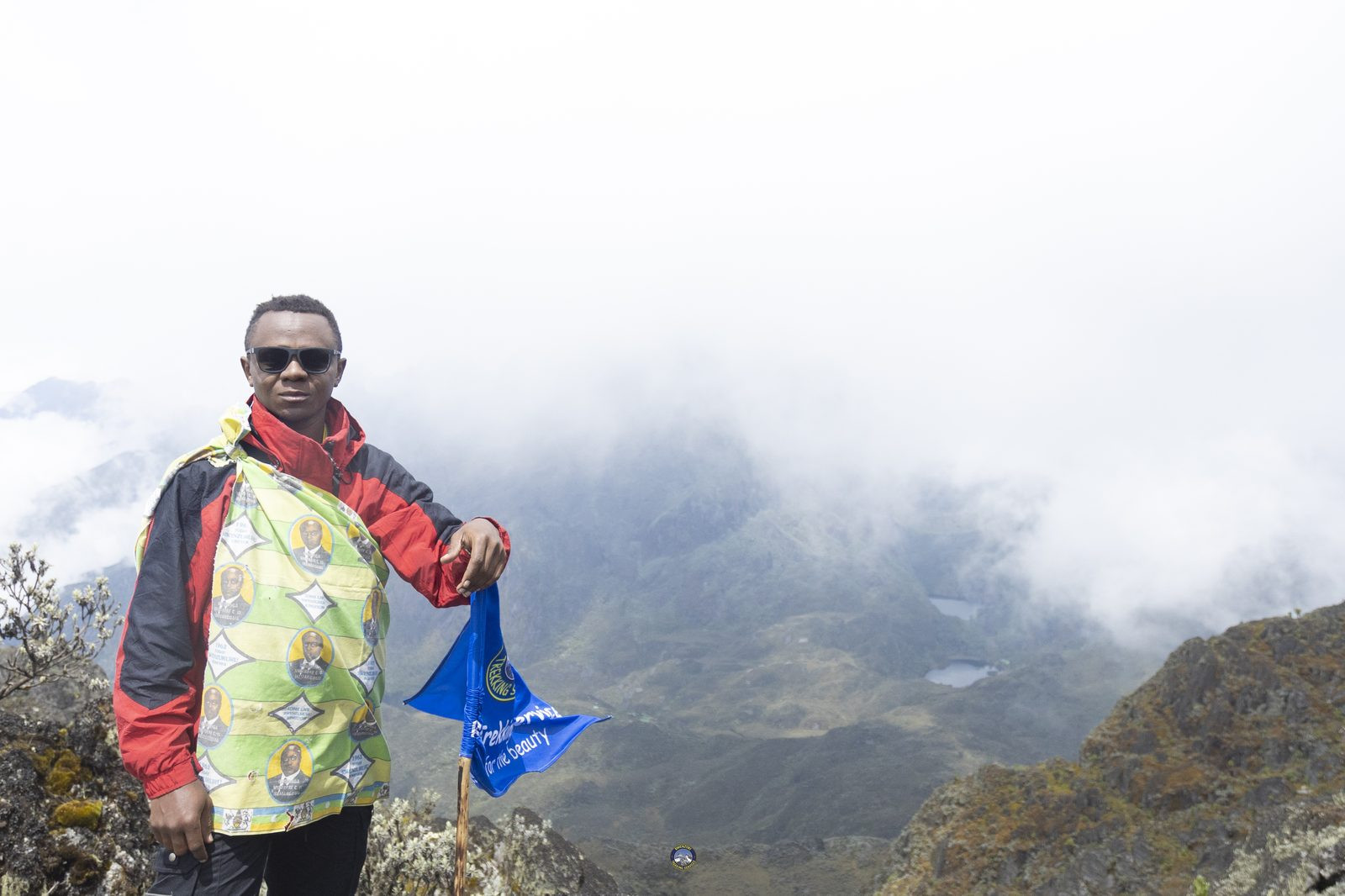 Guide holding a trekking company flag on the mountain